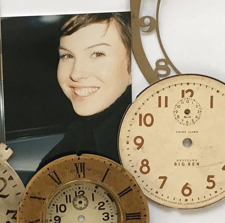 photograph of a beautiful girl smiling at the camera surrounded by vintage clock faces