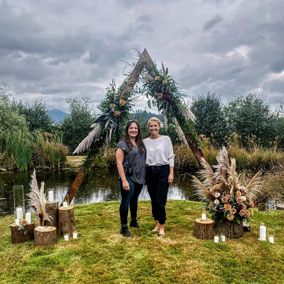 Andrea Kelln and Carmen Williamson of Rosewood Event Design standing in front of wedding decor at a Fraser Valley wedding