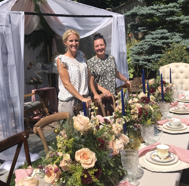 Andrea Kelln and Carmen Williamson standing amongst the high tea baby shower decor and florals they designed for a special event in the fraser valley